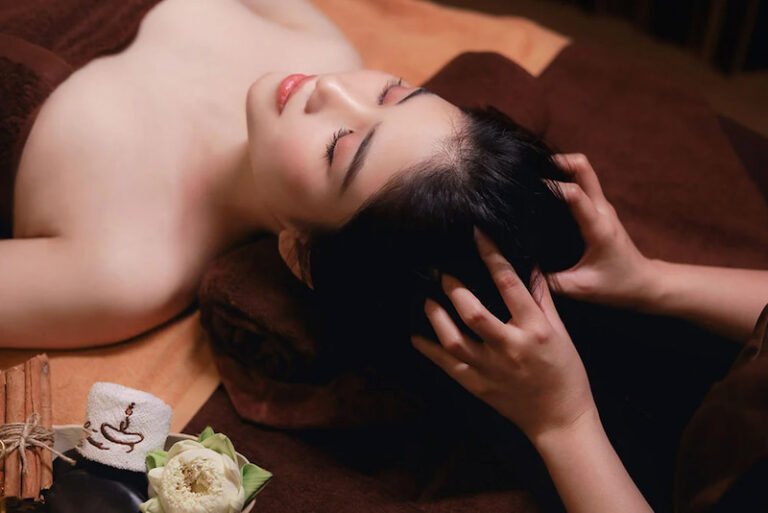 Người phụ nữ thư giãn với liệu pháp massage đầu, mang lại cảm giác an lạc và thoải mái tại spa sang trọng.