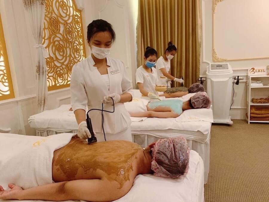 Nhân viên spa đang chăm sóc da chuyên nghiệp cho khách trong không gian sang trọng và thư giãn của thẩm mỹ viện.