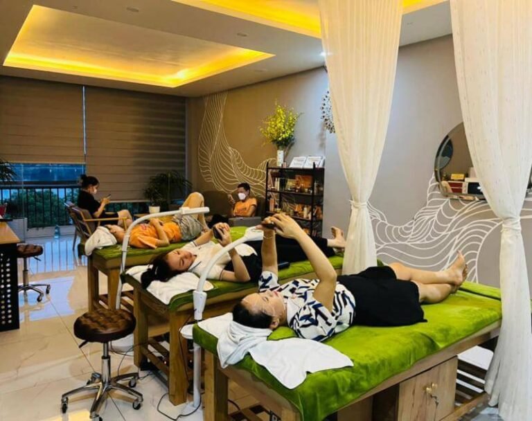 Khách hàng thư giãn trên giường mát-xa tại spa, ánh sáng ấm áp, nội thất sang trọng, không gian yên tĩnh.