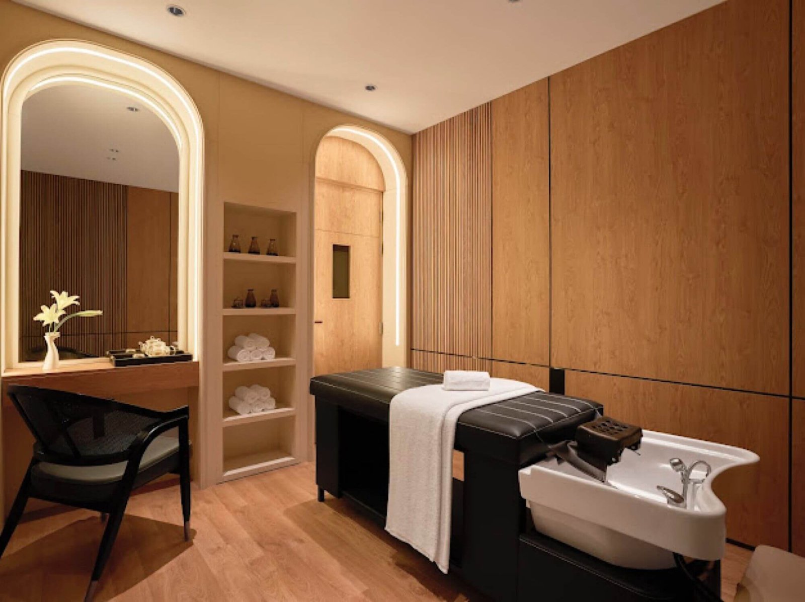 Phòng spa sang trọng với giường massage và nội thất gỗ, ánh sáng ấm áp tạo cảm giác thư giãn.