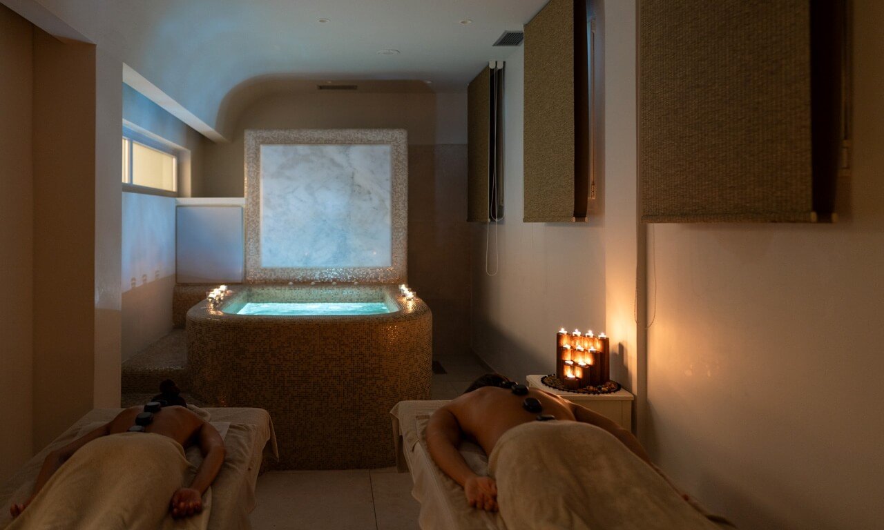 Phòng spa thư giãn với bồn nước nóng và nến lung linh mang đến không gian ấm áp và yên bình.