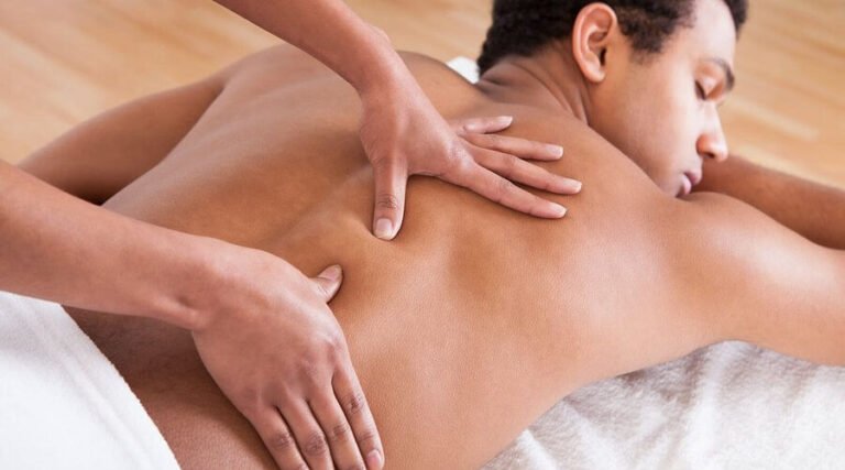 Người đàn ông được massage lưng chuyên nghiệp giúp thư giãn và giảm căng thẳng trên một chiếc giường massage.