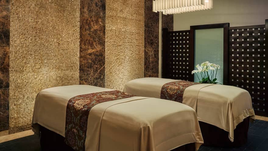 Phòng spa sang trọng với hai giường massage, ánh sáng ấm áp và không gian yên tĩnh, lý tưởng để thư giãn.