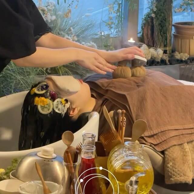 Người thư giãn chăm sóc spa, đắp mặt nạ hoa và massage bằng thảo dược trong không gian yên bình.