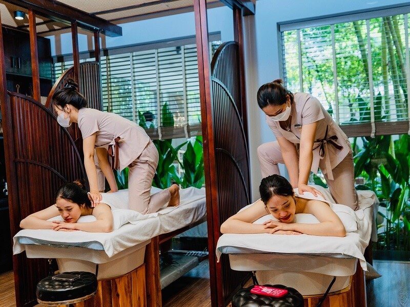 Nhân viên massage thư giãn cho khách hàng tại spa với không gian nội thất hiện đại, ánh sáng tự nhiên.