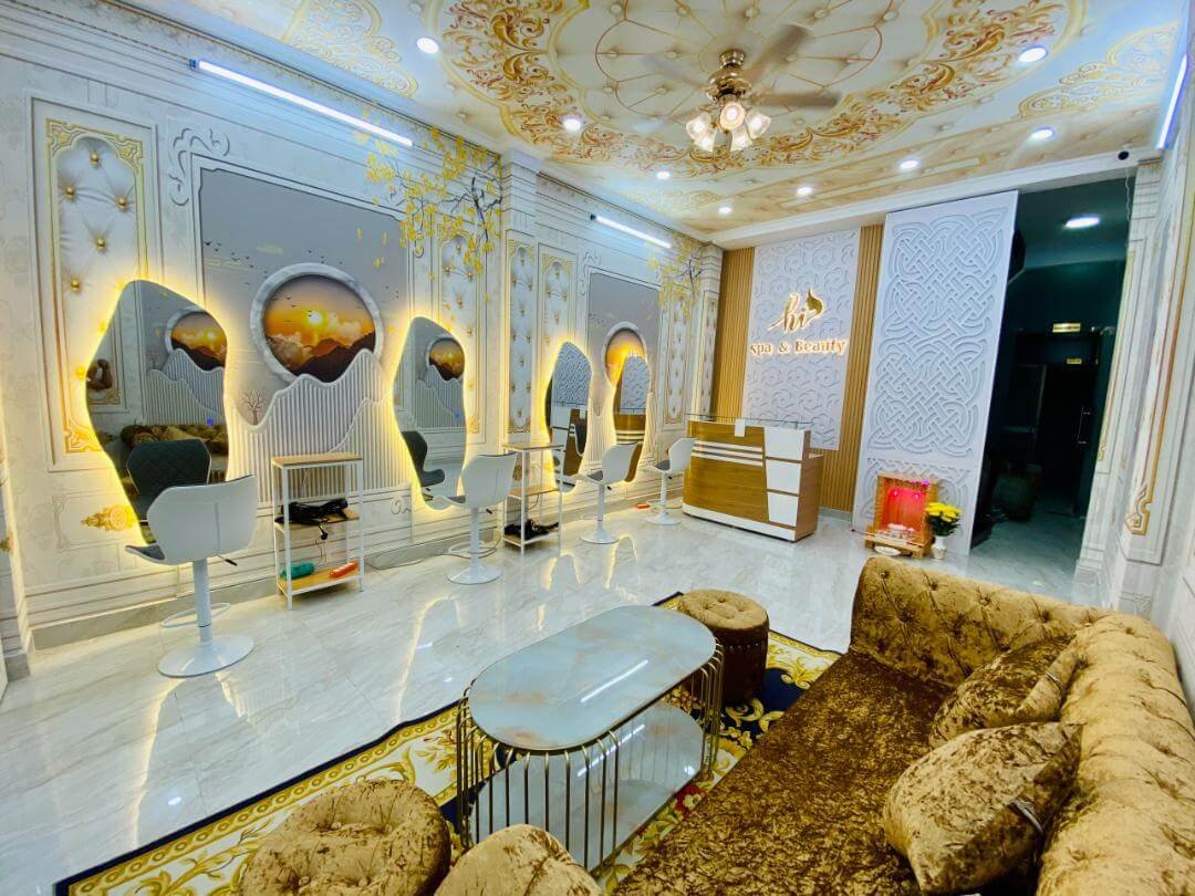 Phòng làm tóc và spa sang trọng với nội thất ánh vàng và ghế salon hiện đại.