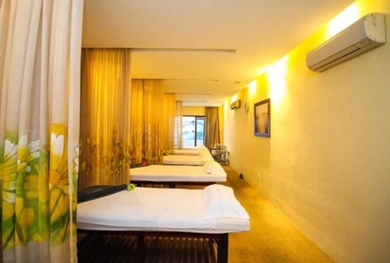 Phòng spa thư giãn với giường mát-xa và rèm trang trí tinh tế. Không gian yên tĩnh, ánh sáng dịu nhẹ.