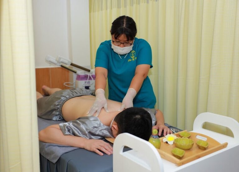 Nhân viên spa đang phục vụ khách hàng tại phòng massage, giúp thư giãn và giảm căng thẳng cơ thể.
