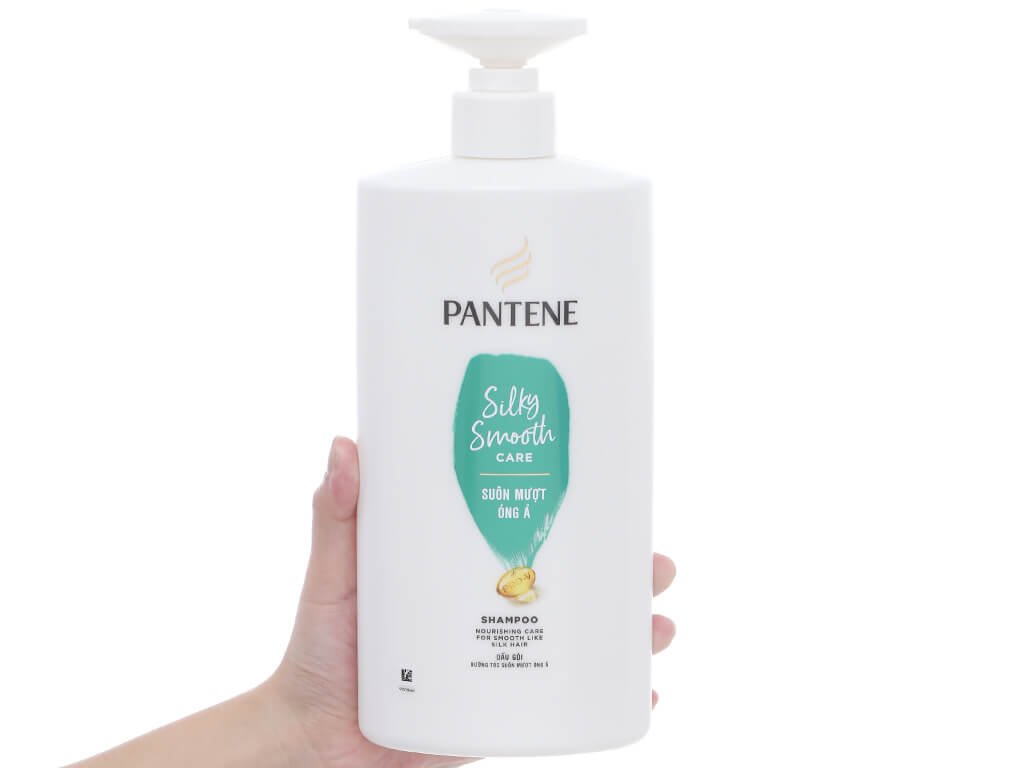 Người cầm chai dầu gội Pantene Silky Smooth Care màu trắng, dung tích lớn, có vòi bơm.