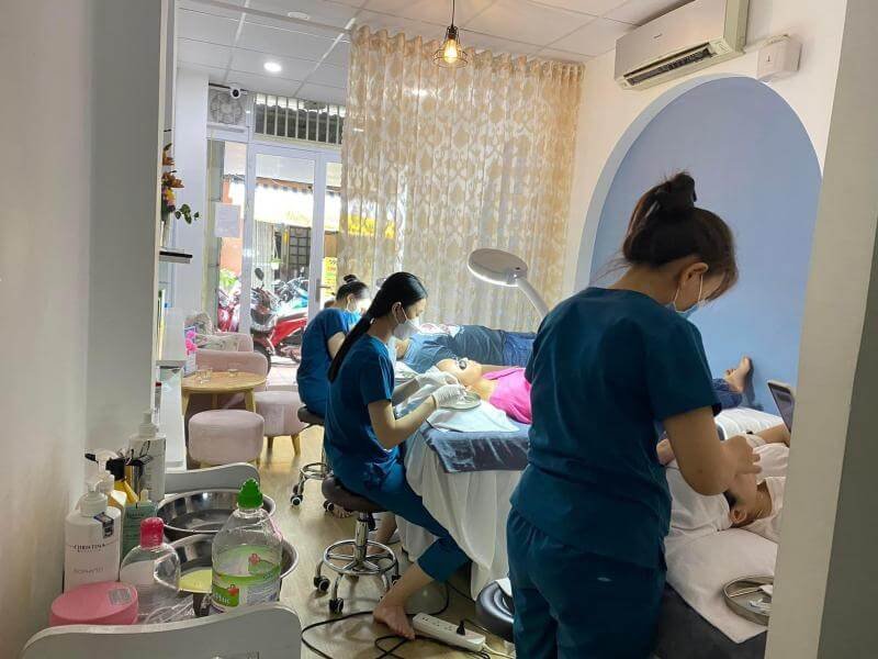 Nhân viên spa chăm sóc da mặt cho khách hàng tại một thẩm mỹ viện nhỏ, tạo không gian thư giãn thoải mái.