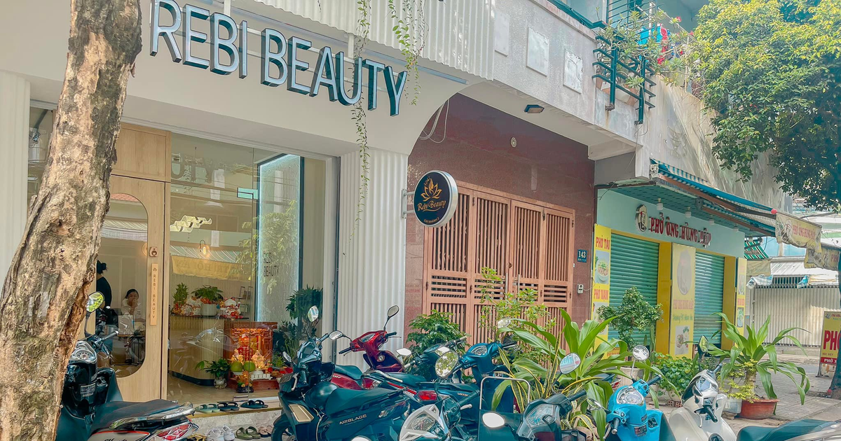 Mặt tiền của salon làm đẹp với nhiều xe máy đỗ bên ngoài trên một con phố yên tĩnh.