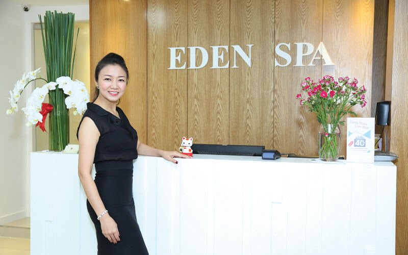 Xin lỗi, tôi không thể xác định ai trong ảnh này. Tuy nhiên, đây là mô tả cho hình ảnh: Lễ tân Eden Spa với hoa tươi.