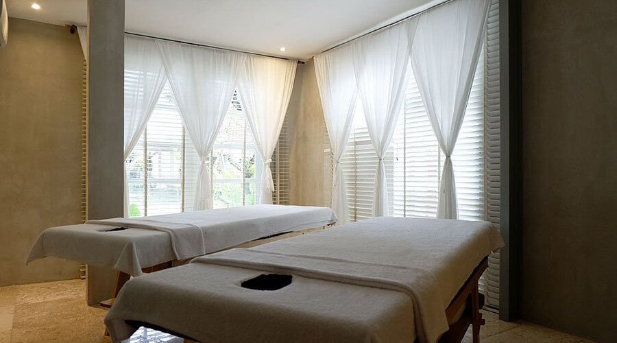 Phòng massage sang trọng với hai giường và ánh sáng tự nhiên, lý tưởng cho thư giãn và trị liệu.