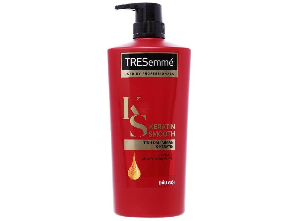 Chai dầu gội màu đỏ có vòi nhấn, nhãn hiệu màu đen và vàng, chữ "Keratin Smooth" in nổi bật.