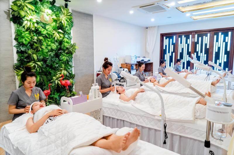 Nhân viên spa chăm sóc da mặt cho khách hàng tại phòng trị liệu sang trọng, nội thất hiện đại.