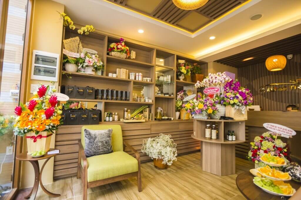Spa sang trọng với hoa tươi và sản phẩm chăm sóc, không gian ấm cúng pha ánh sáng vàng.
