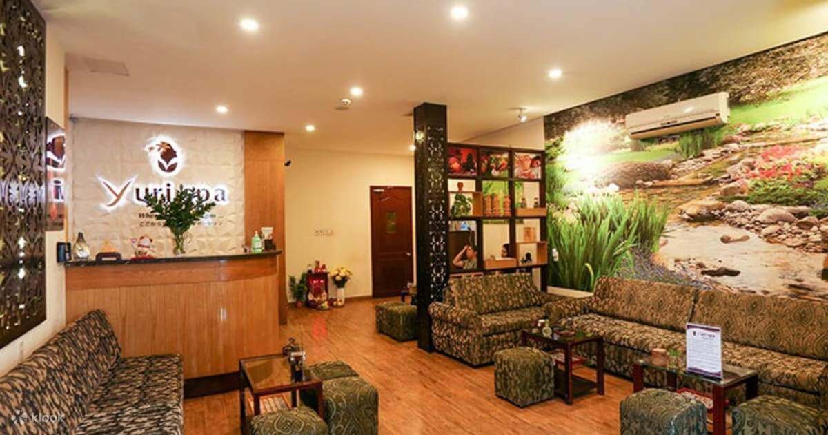 Khu vực tiếp tân spa trang nhã với nội thất ấm cúng và tranh tường thiên nhiên xanh mát.