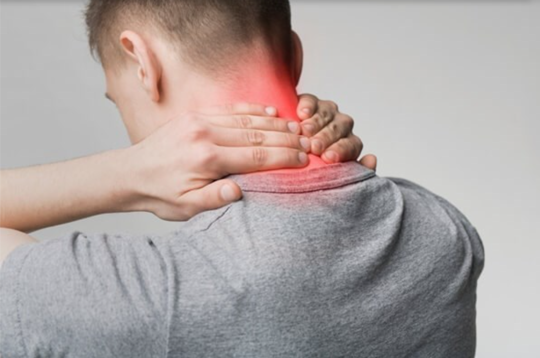 Người đang xoa bóp cổ với vùng cổ đỏ, có thể biểu thị cảm giác đau hoặc căng thẳng.