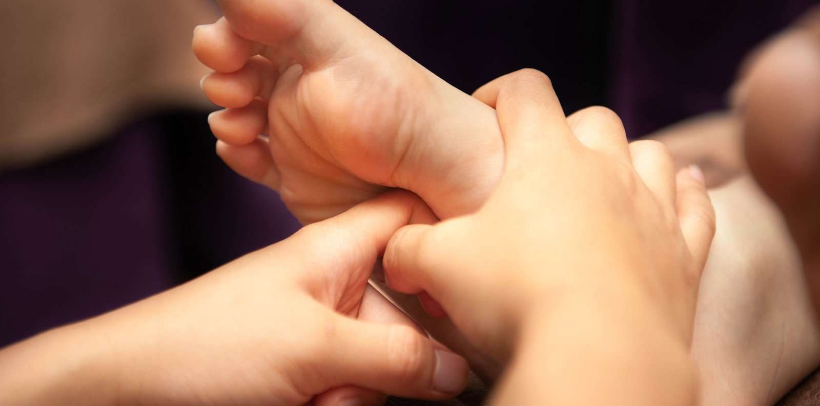 Hai bàn tay đang xoa bóp lòng bàn chân, tạo cảm giác thư giãn và thoải mái.