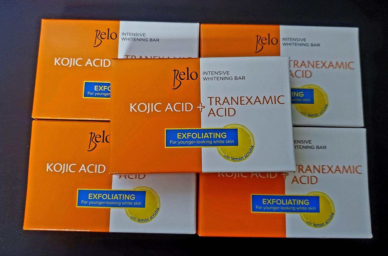 Hộp xà phòng dưỡng da với axit Kojic và Tranexamic, nhãn màu cam và trắng, thông tin tẩy tế bào chết.