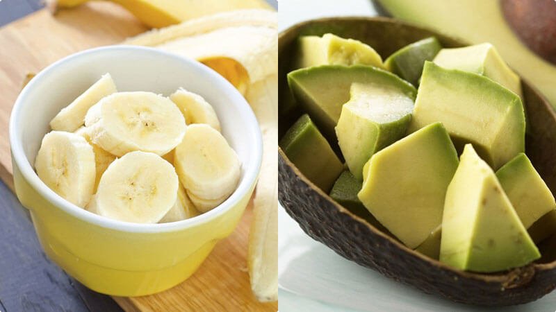Chuối cắt lát trong bát và bơ cắt miếng trong vỏ, đặt trên bề mặt phẳng.