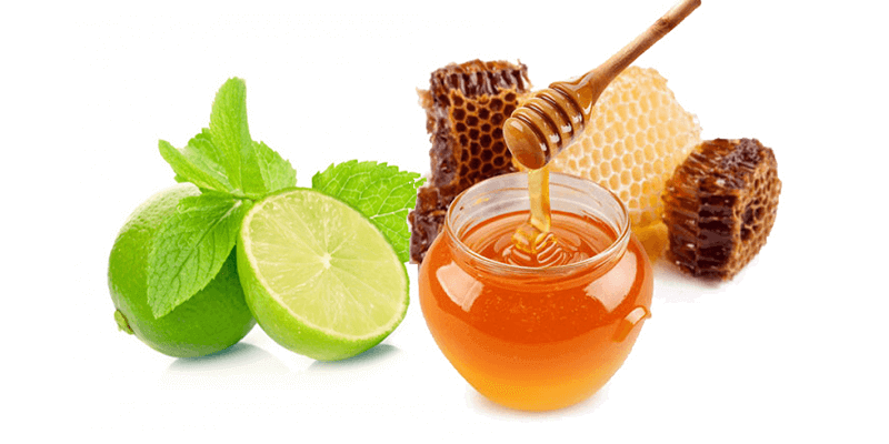 Chanh, lá bạc hà, mật ong trong lọ và sáp ong, được sắp xếp trên nền trắng.