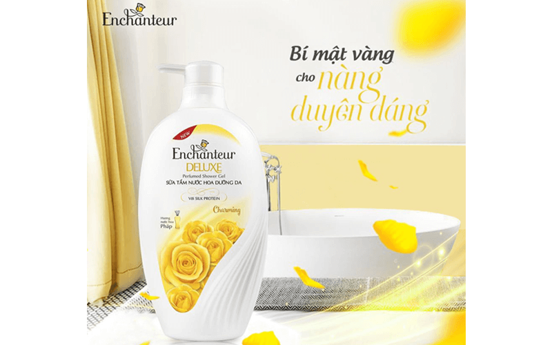 Chai sữa tắm Enchanteur Deluxe đặt trên nền phòng tắm với hoa hồng vàng trang trí.