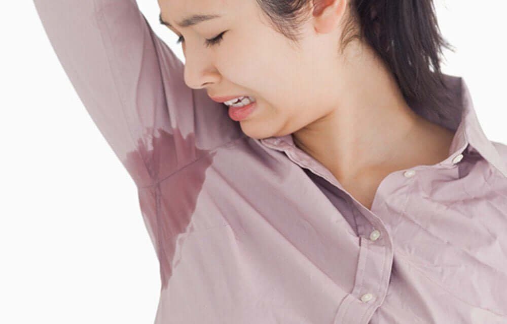 Người mặc áo sơ mi màu tím nhạt với vết ướt rõ rệt dưới cánh tay phải.