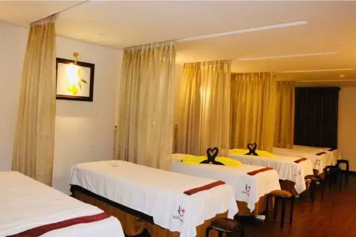 Phòng massage với nhiều giường, rèm ngăn cách và ánh sáng dịu, tạo không gian thư giãn và yên tĩnh.