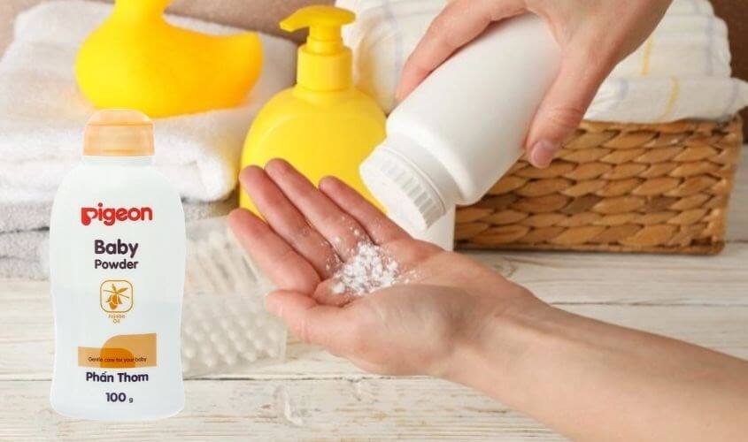 Người đang đổ phấn rôm ra tay bên cạnh chai phấn rôm và các vật dụng chăm sóc trẻ em.
