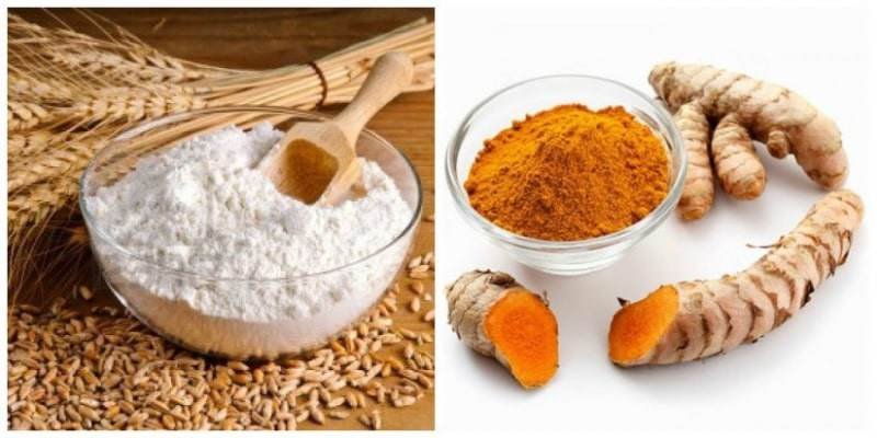 Bột mì và bột nghệ trong tô thủy tinh, bên cạnh là nhánh nghệ và lúa mì trên bề mặt gỗ.