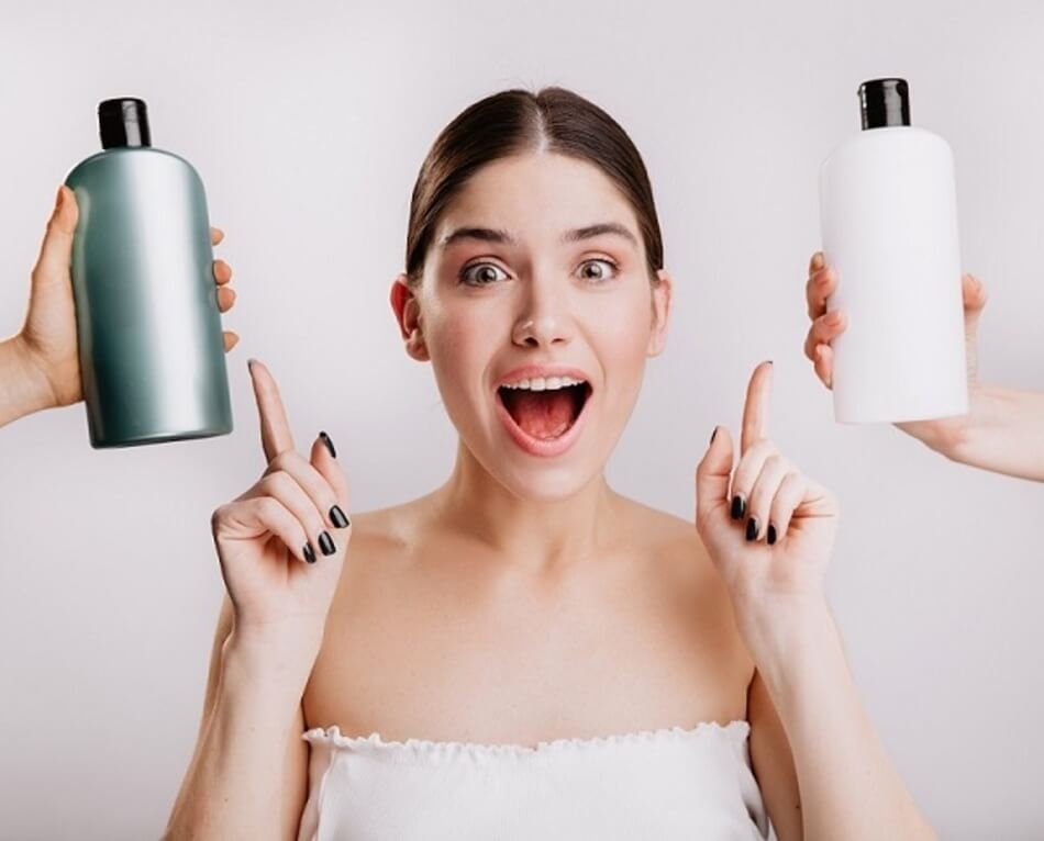 Người phụ nữ cầm hai chai nhựa màu xanh và trắng, biểu cảm ngạc nhiên, trên nền trắng.