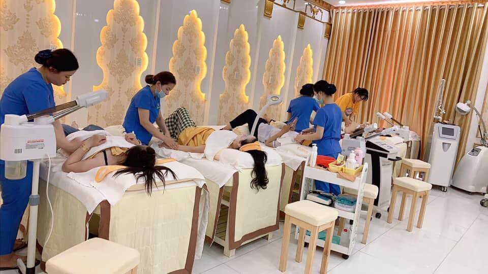 Một nhóm người đang thực hiện liệu trình chăm sóc da tại spa, với các thiết bị và giường chuyên dụng.