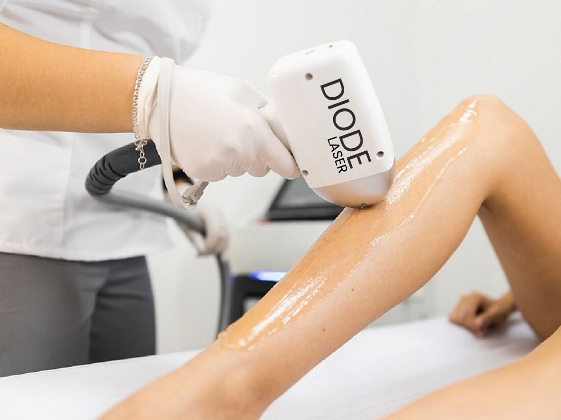 Người đang sử dụng máy laser diode để điều trị vùng da chân trong một phòng thẩm mỹ.