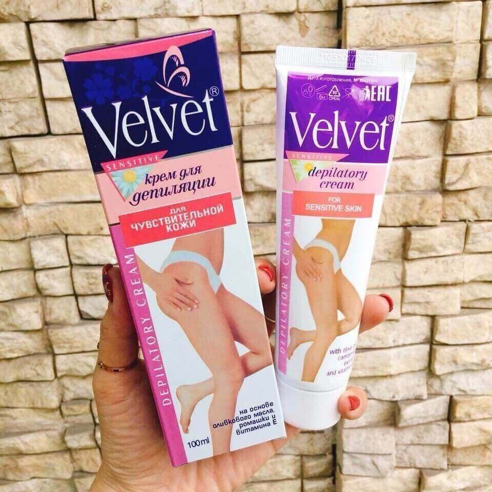 Hai sản phẩm kem tẩy lông Velvet dành cho da nhạy cảm, gồm hộp giấy và tuýp kem, nền gạch.