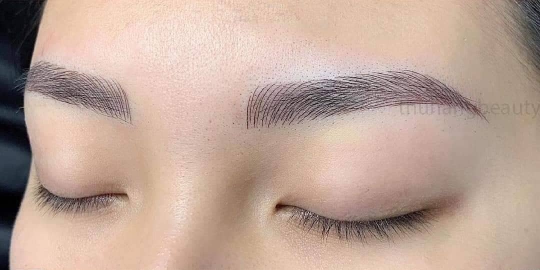Cận cảnh đôi mắt nhắm với lông mày được phun xăm tỉ mỉ, nền da mịn màng.