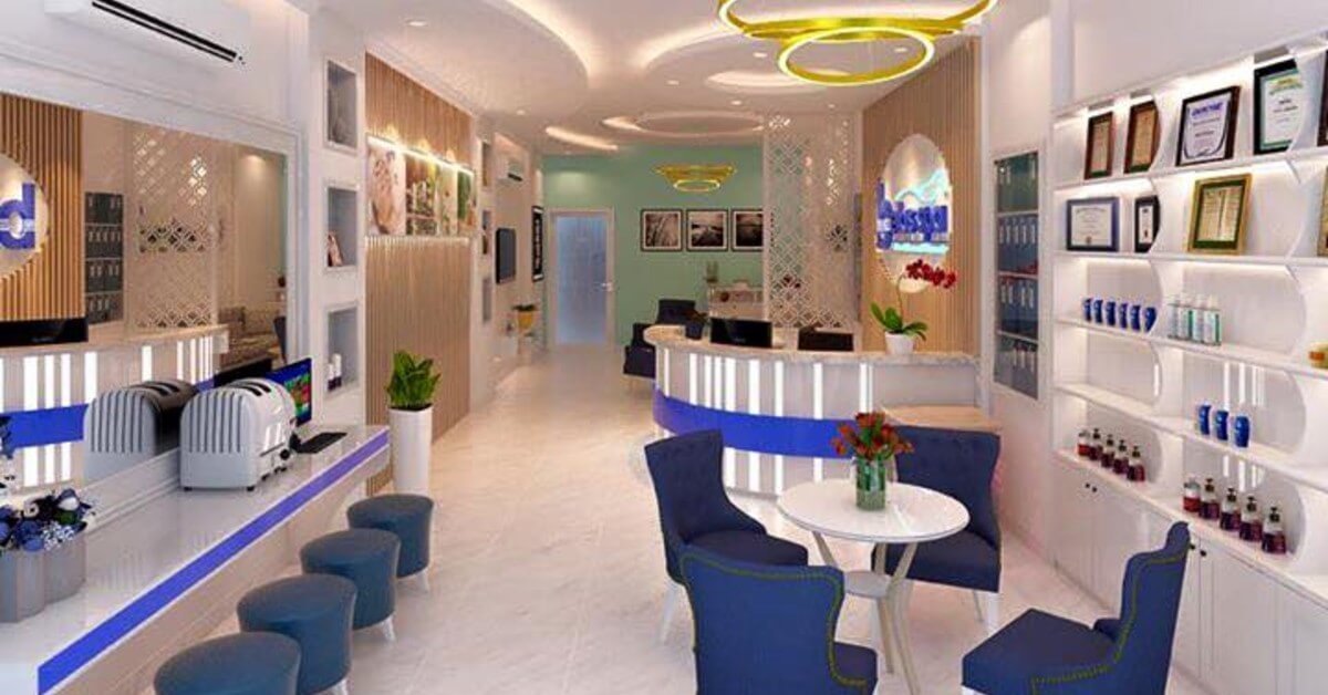 Phòng tiếp tân hiện đại với nội thất trang nhã, có ghế xanh, bàn tròn và kệ trưng bày sản phẩm.
