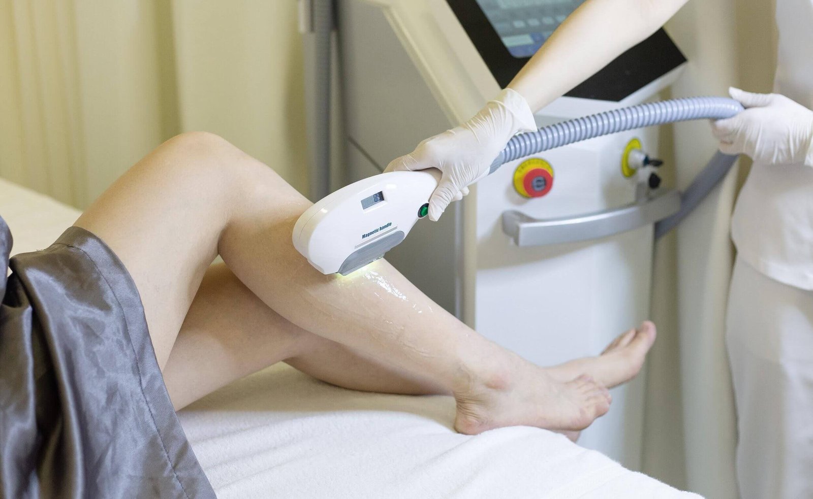 Người đang thực hiện liệu pháp laser trên chân với máy móc chuyên dụng trong môi trường thẩm mỹ.