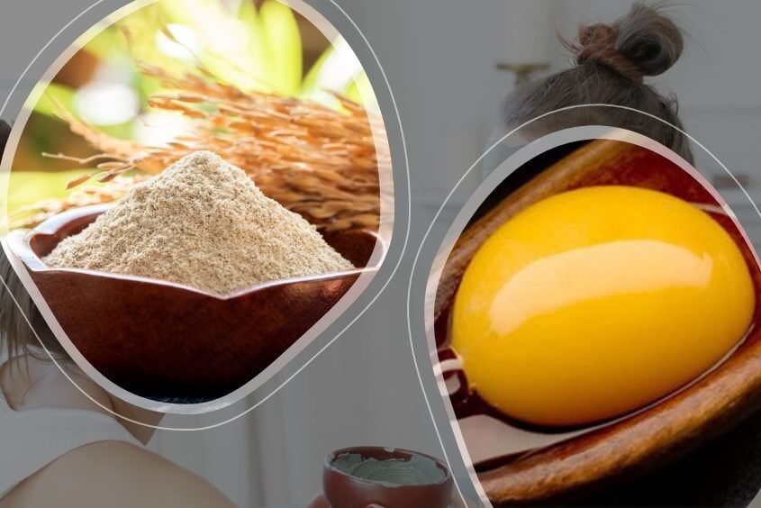 Bột cám gạo trong bát gỗ và lòng đỏ trứng trên muỗng, với nền tóc búi gọn phía sau.