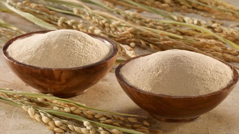 Hai bát đựng bột màu trắng ngà, đặt trên nền đá, xung quanh có các nhánh lúa khô.