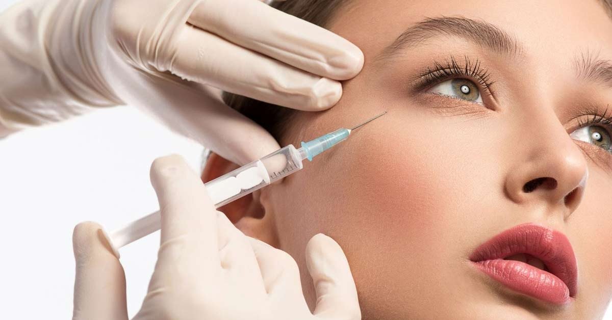 Người đeo găng tay tiêm kim vào vùng da gần mắt của một người.