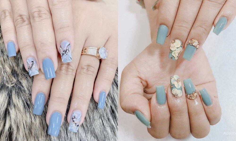 Hai bàn tay với móng tay sơn màu xanh, một bên có họa tiết chữ và một bên có trang trí hoa nổi.