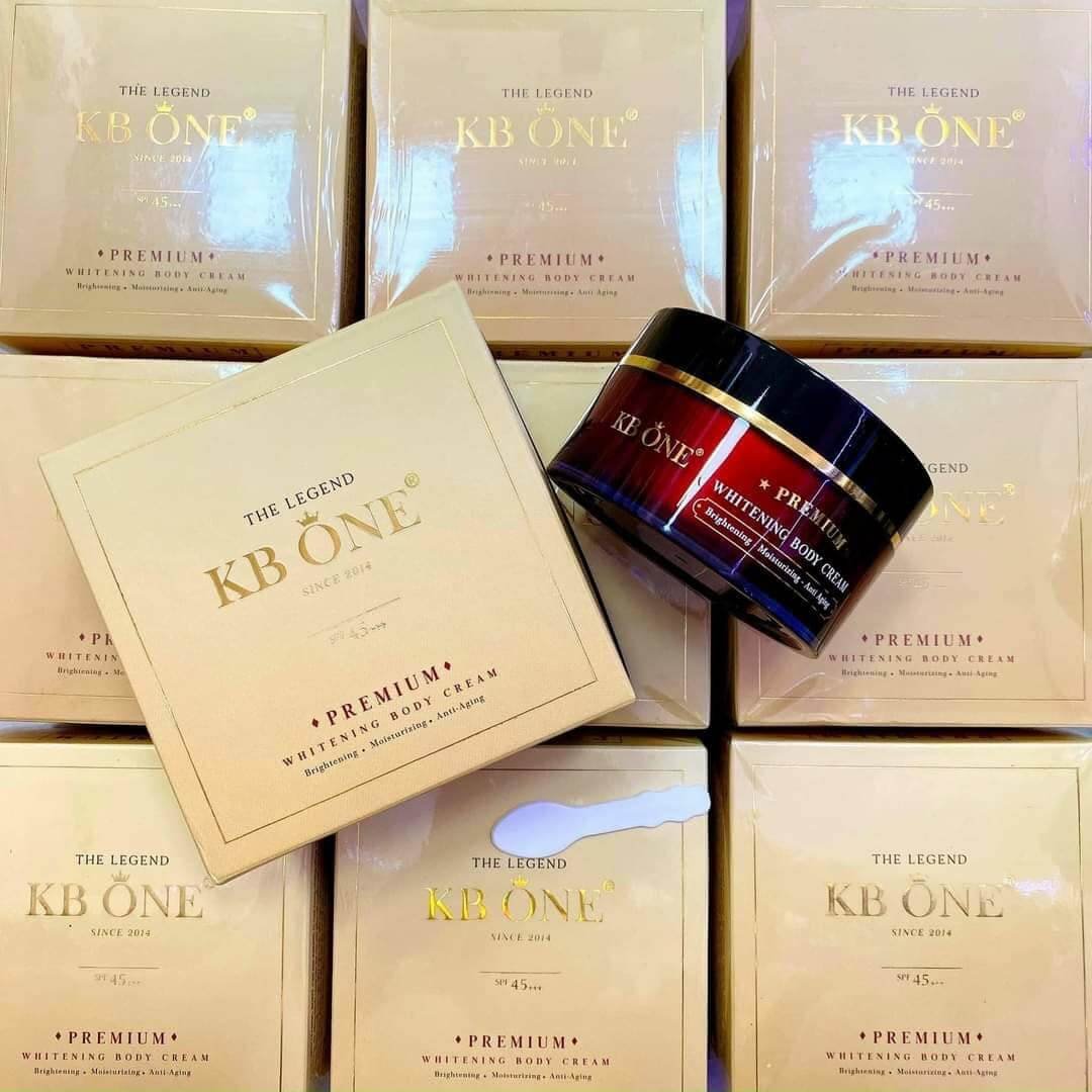 Hộp kem dưỡng trắng da KB One trên nền các hộp tương tự, với bao bì màu vàng nhạt và chữ in nổi bật.