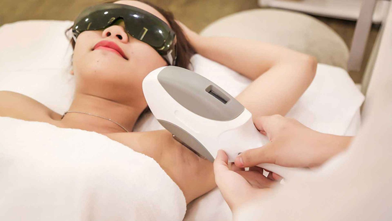 Người đang nằm thư giãn trên ghế trong khi được điều trị bằng máy công nghệ cao ở vùng nách.