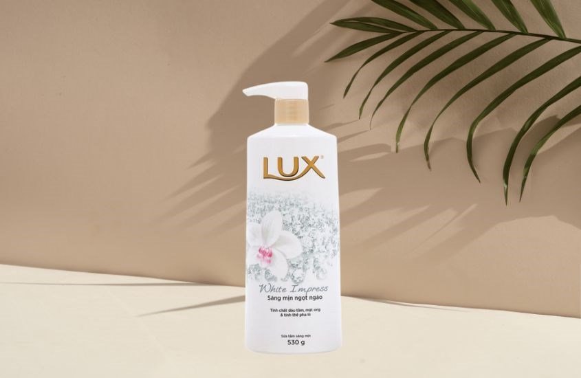 Top 14 Sữa Tắm Trắng Da Cho Nữ Tốt Nhất, Được Đánh Giá Cao Hiện Nay 11 Chai sữa tắm có vòi nhấn, thương hiệu Lux, nền màu be, có lá cây trang trí phía sau.