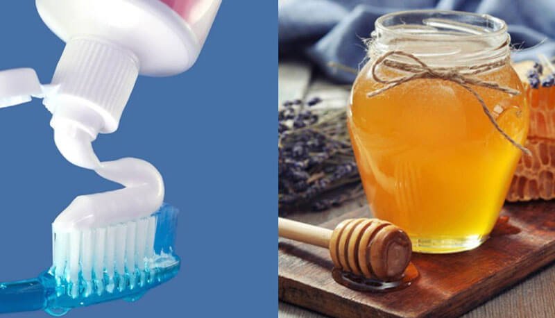 Hình ảnh gồm một bàn chải với kem đánh răng và một hũ mật ong trên nền gỗ.