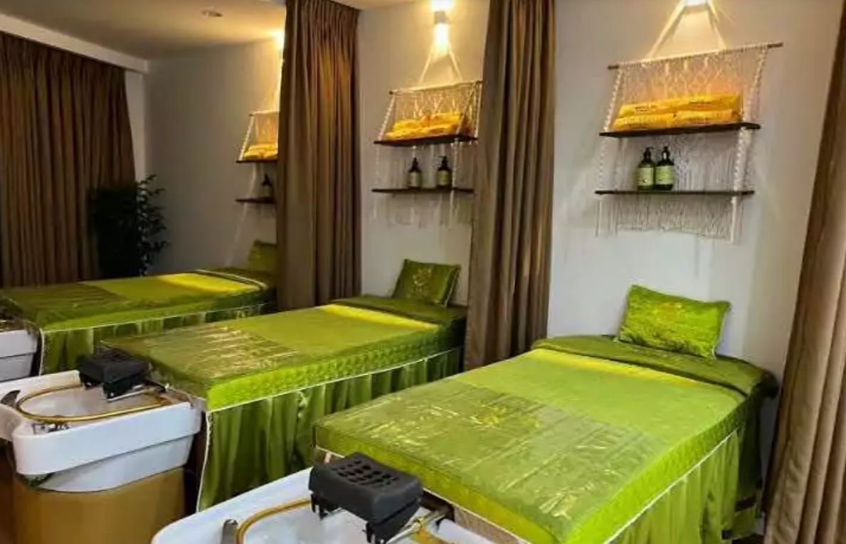 Top 10+ Địa Chỉ Giác Hơi Gần Đây Dịch Vụ Tốt Nhất Hiện Nay 5 Phòng spa với ba giường trải ga màu xanh lá, bên cạnh là bồn rửa và kệ chứa chai lọ trang trí.