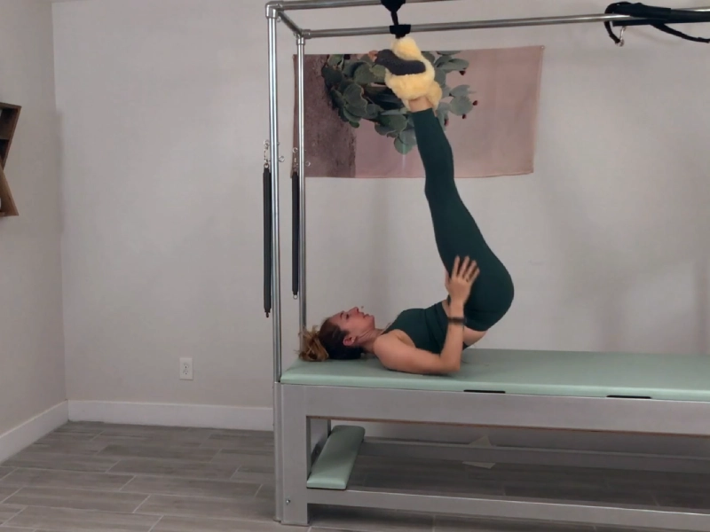 bai-tap-pilates-half-and-full-hanging-tren-cadillac-7 Hạ người xuống Cadillac và tháo dây treo.
